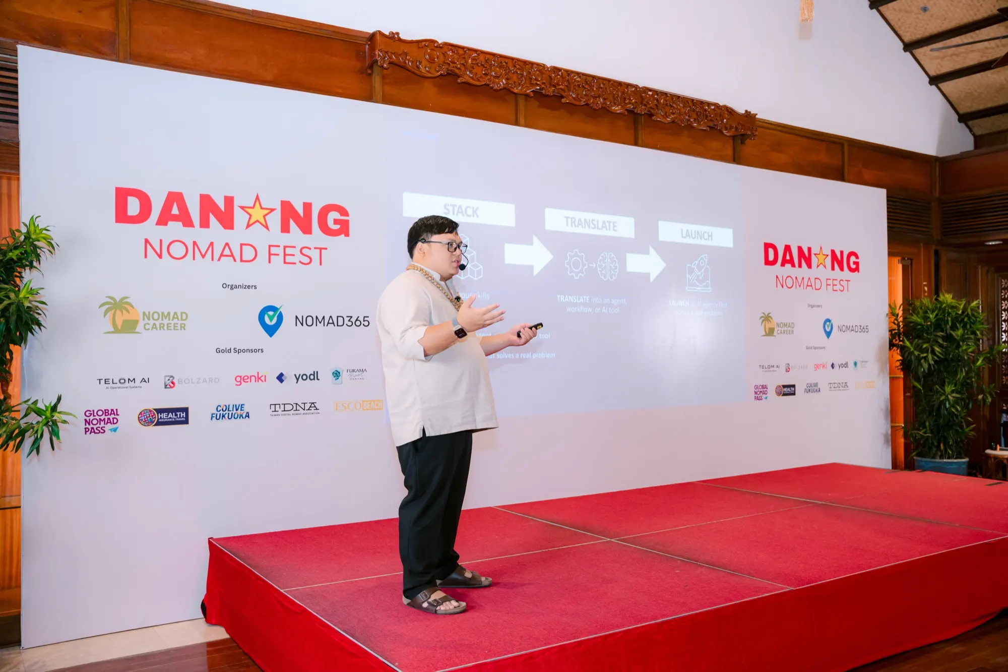 Cris Vinson speaking on stage in Da Nang